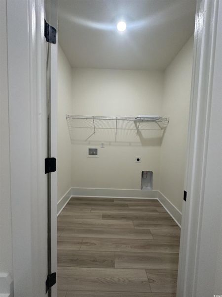 Laundry room with washer hookup, light wood-style flooring, and electric dryer hookup