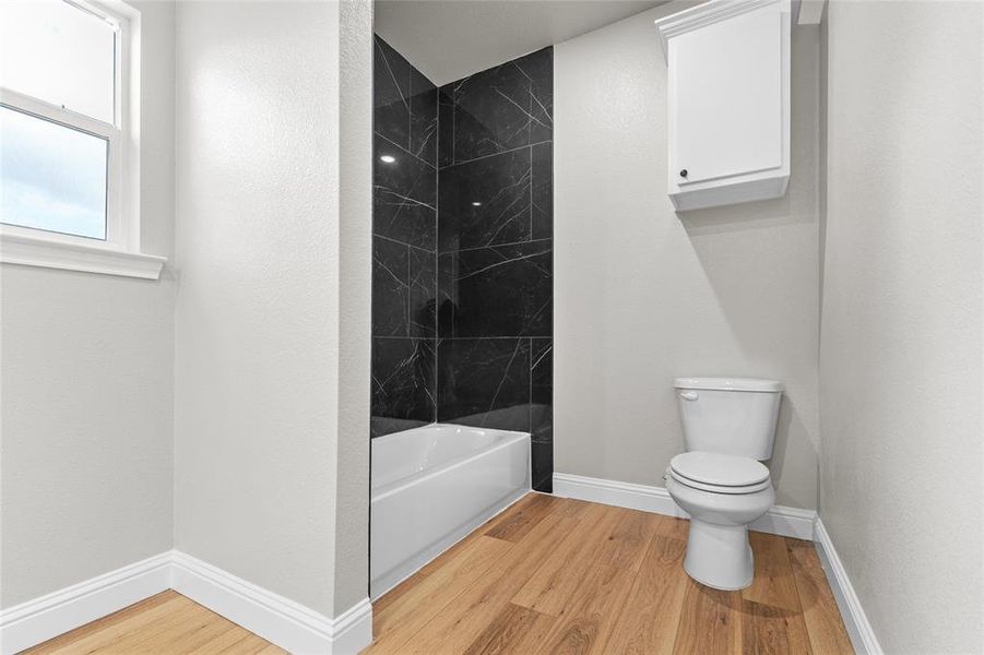 Bathroom featuring light wood-style floors and tub / shower combination