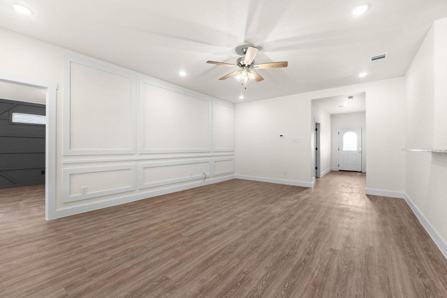 Empty room with wood finished floors, a decorative wall, recessed lighting, and a ceiling fan