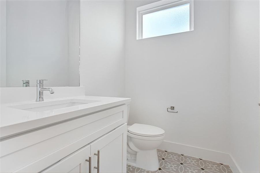 Bathroom featuring tile patterned floors, vanity, and toilet