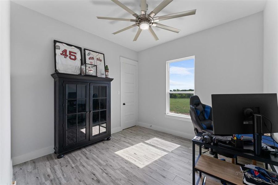 Room featuring wood-finish flooring, a contemporary ceiling fan with integrated lighting, and light gray wall finishes