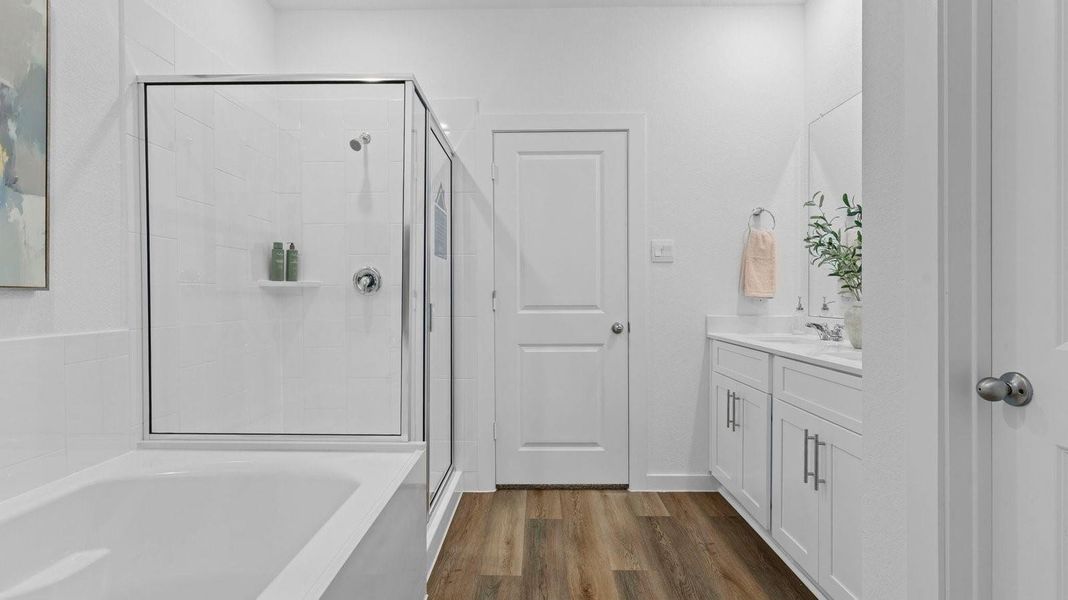 Primary bathroom with a glass-enclosed standing shower and separate soaking tub.