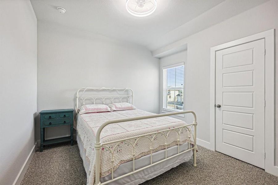 View of carpeted bedroom with nook and fandalier