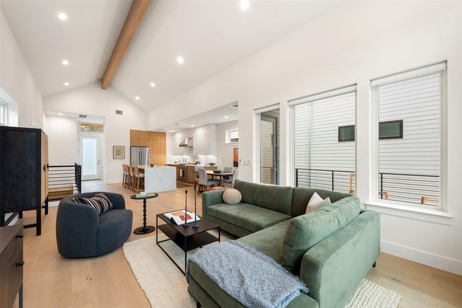 An airy great room presents vaulted ceilings and an open floorplan, merging living, dining, and kitchen spaces. An airy great room presents vaulted ceilings and an open floorplan, merging living, dining, and kitchen spaces.