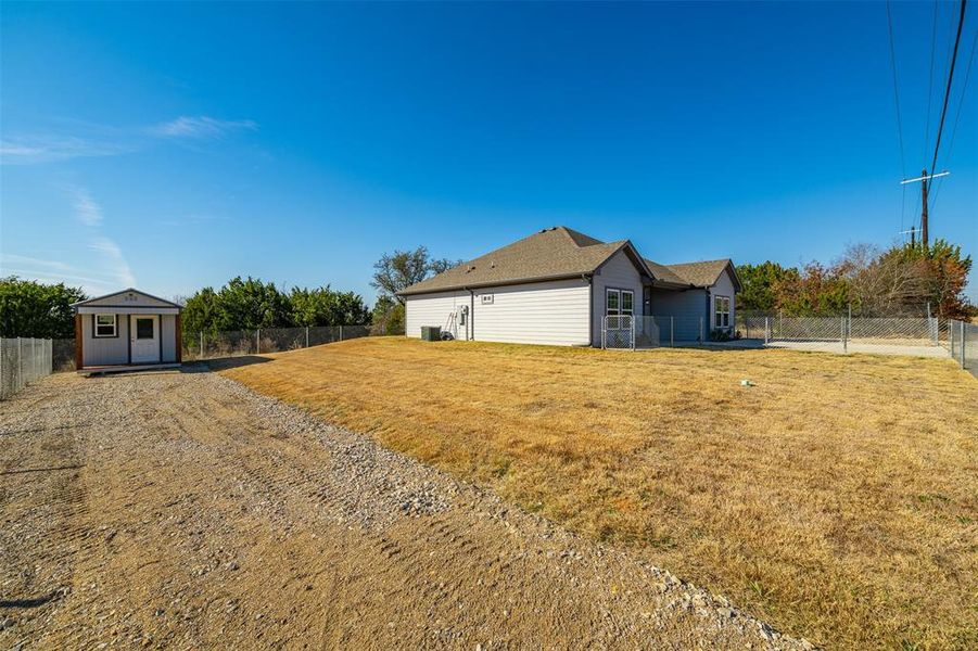 View of side of home with a yard and an outdoor structure