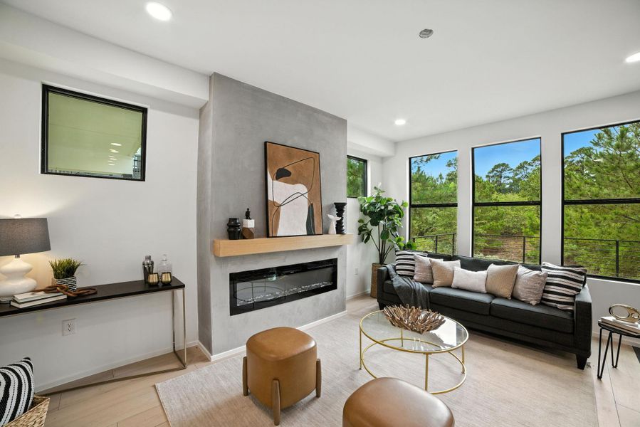 Living room featuring a large fireplace, wood finished floors, and recessed lighting Living room featuring a large fireplace, wood finished floors, and recessed lighting