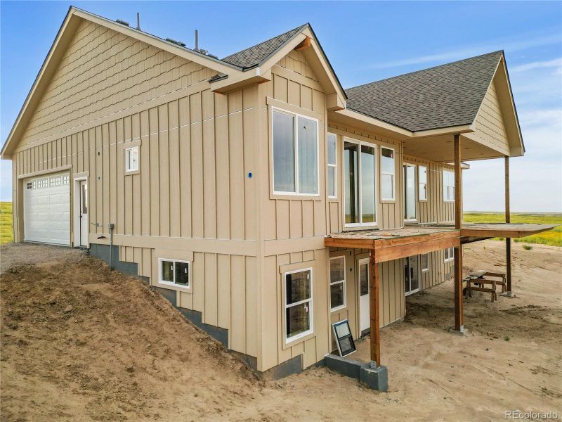 Angled aerial shot showing garage orientation and scenic surroundings during early construction.