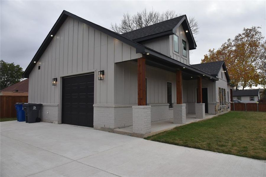 View of home's exterior featuring a yard, a porch, and a garage