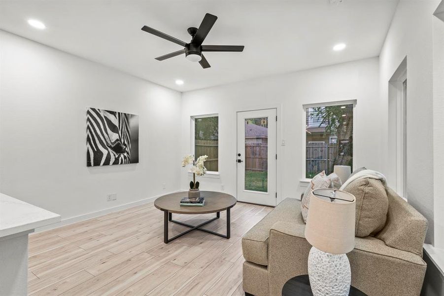 Living room featuring light wood finished floors, recessed lighting, and a ceiling fan Living room featuring light wood finished floors, recessed lighting, and a ceiling fan