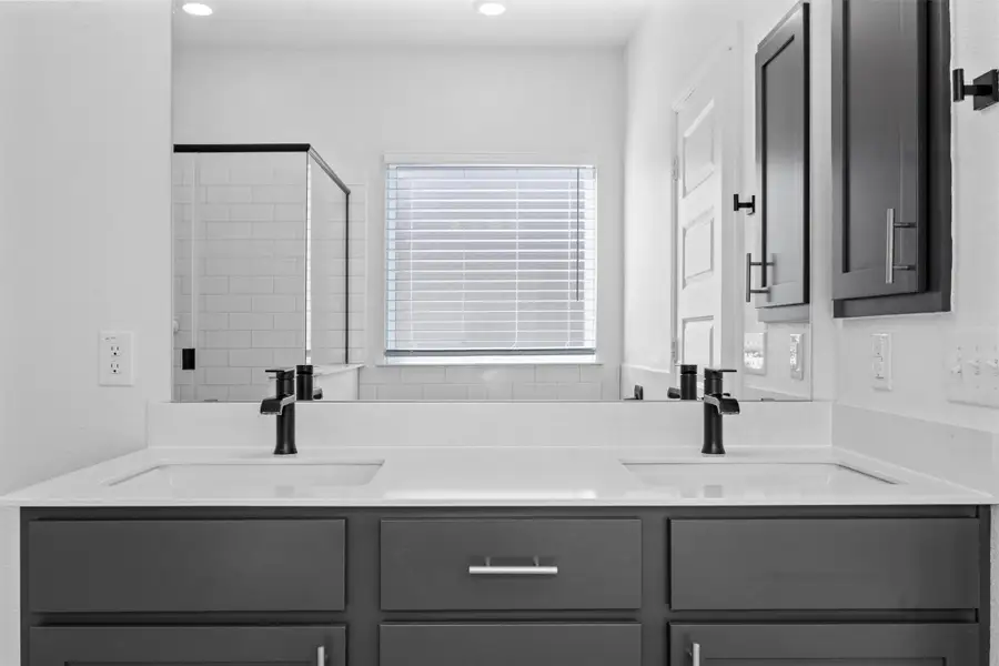 Full bath featuring double vanity and a shower stall