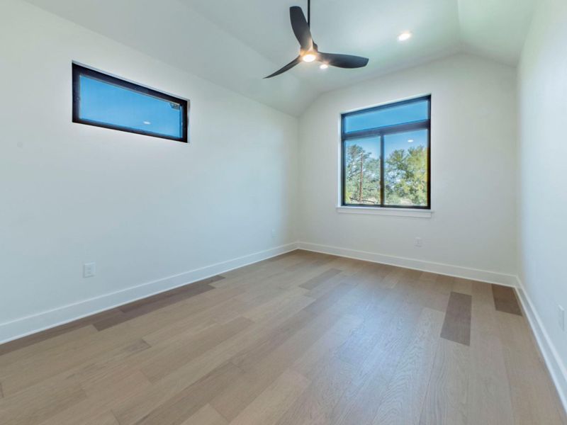 Empty room with light wood-type flooring, lofted ceiling, recessed lighting, and ceiling fan Empty room with light wood-type flooring, lofted ceiling, recessed lighting, and ceiling fan