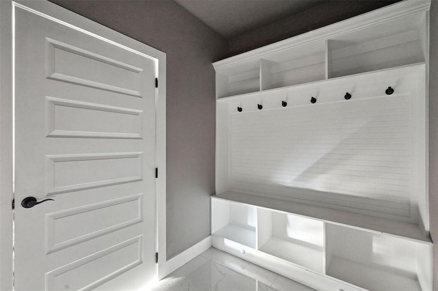 Mudroom featuring baseboards and light marble finish floors Mudroom featuring baseboards and light marble finish floors