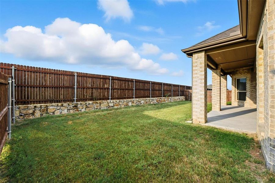 Fenced backyard with a patio area Fenced backyard with a patio area