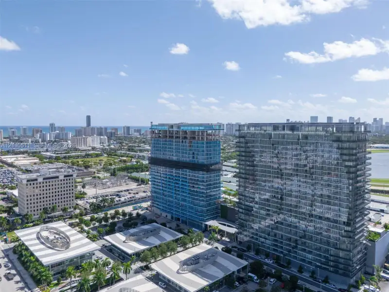 Aerial perspective of high-rise structures featuring glass-paneled facades and architectural symmetry