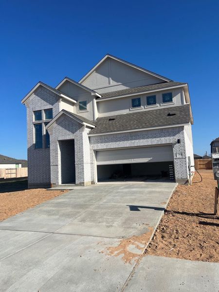 View of front of house featuring concrete driveway, a garage, brick siding, and a shingled roof