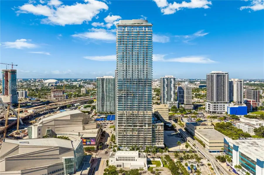 High-rise residential tower featuring a glass facade, multiple levels of private balconies, and a reinforced concrete structure
