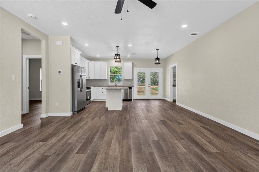 Rich wood-look flooring stretches across a seamless open floorplan connecting the living space and kitchen. Rich wood-look flooring stretches across a seamless open floorplan connecting the living space and kitchen.