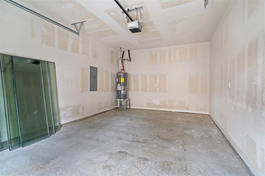 Garage with water heater, electric panel, and a garage door opener Garage with water heater, electric panel, and a garage door opener