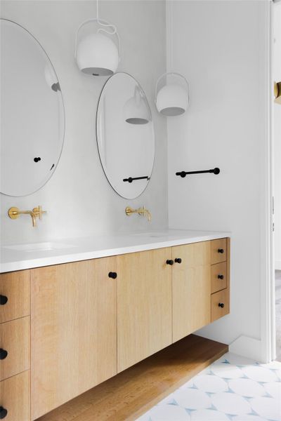 Guest bathroom features a dual floating vanity, designer fixtures, and modern tile choices.