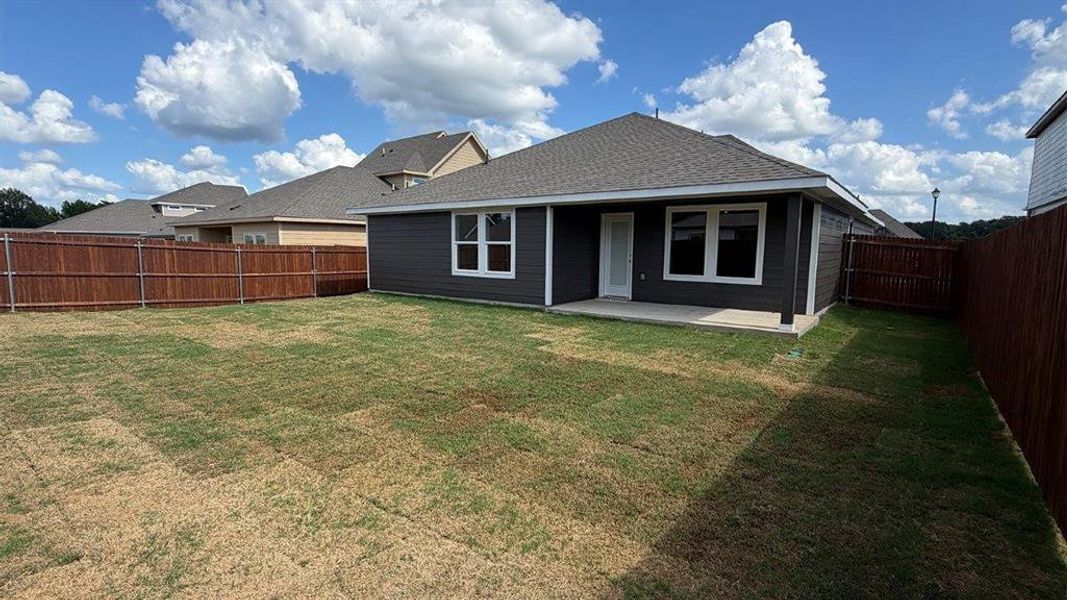Rear exterior with dark gray siding and white trim windows
