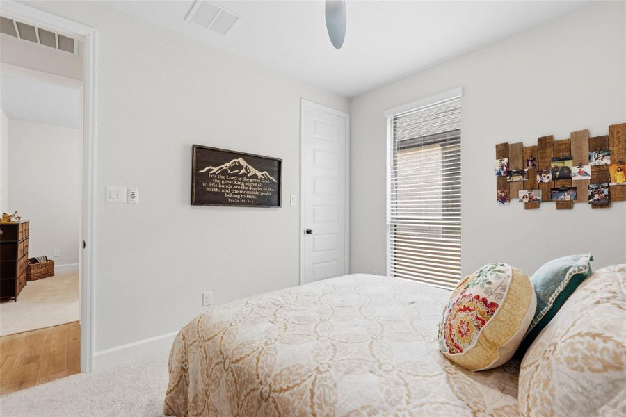 Light-filled room featuring a single window with horizontal blinds, a white paneled door, and neutral wall tones