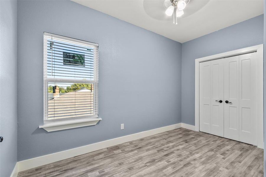 Unfurnished bedroom featuring a closet, light wood-type flooring, and ceiling fan