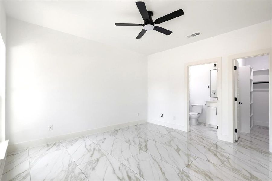 Spacious room featuring large format marble-look tile flooring, white walls, and a contemporary ceiling fan with integrated lighting