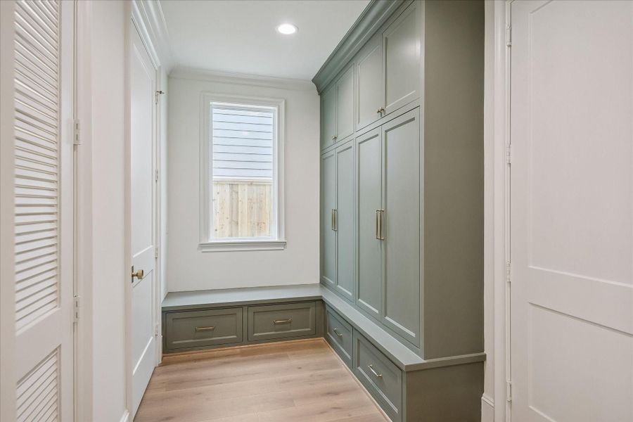 Mudroom/drop zone offers convenient access to the epoxy-finished 2-car garage.