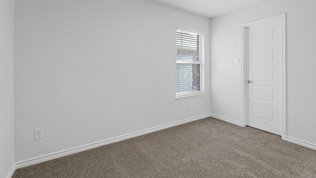 Carpeted spare room featuring baseboards