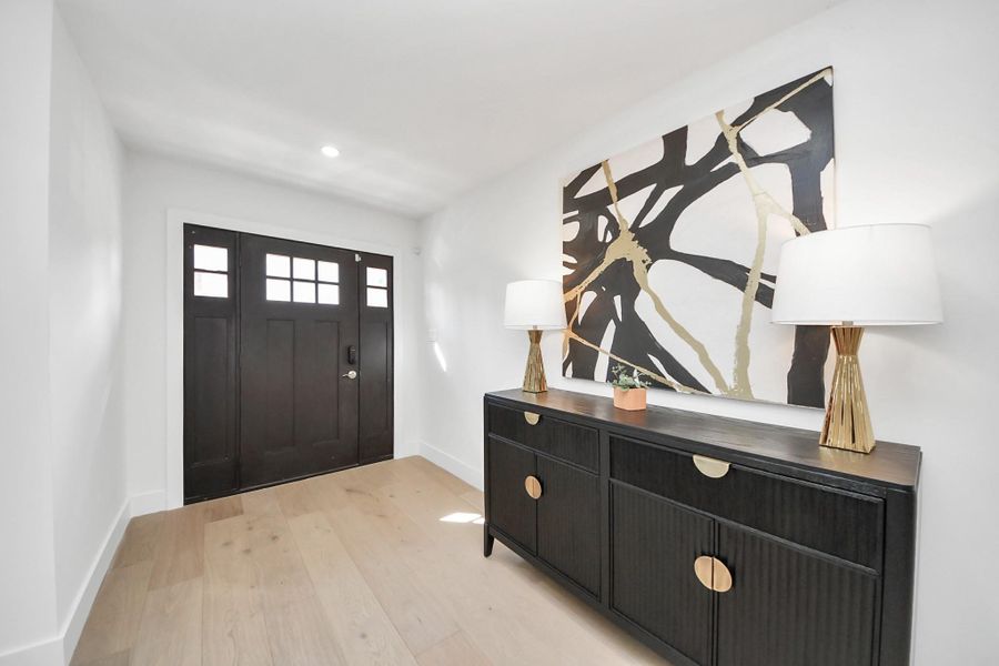 Welcoming entryway with modern front door, neutral walls, and elegant white oak wood flooring. Welcoming entryway with modern front door, neutral walls, and elegant white oak wood flooring.