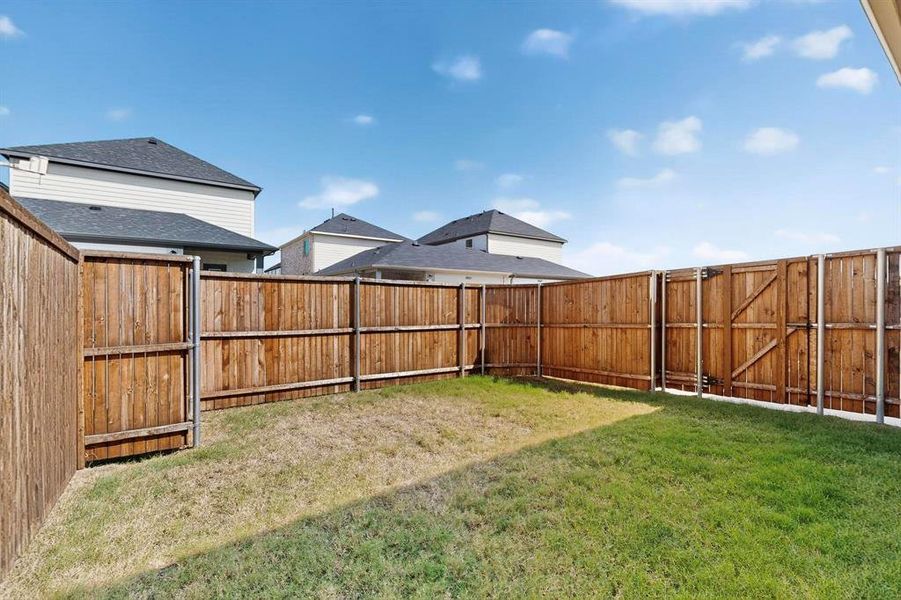 Fenced backyard featuring a gate Fenced backyard featuring a gate