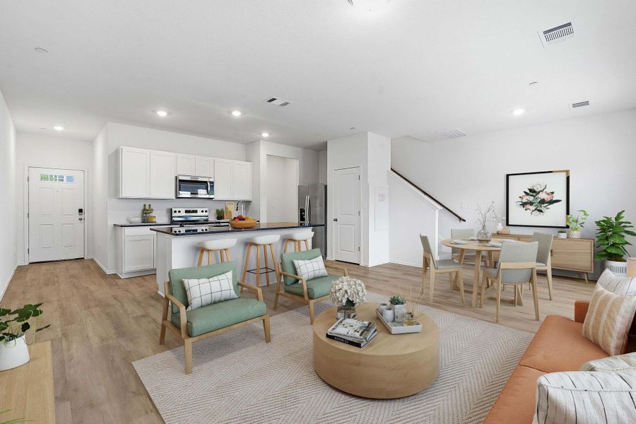 Open-concept living space featuring wood-finish flooring, a kitchen with white cabinetry and stainless steel appliances, a breakfast bar, and a dining area Open-concept living space featuring wood-finish flooring, a kitchen with white cabinetry and stainless steel appliances, a breakfast bar, and a dining area