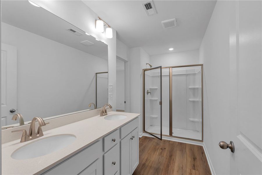 This spacious primary bathroom features a dual van This spacious primary bathroom features a dual van