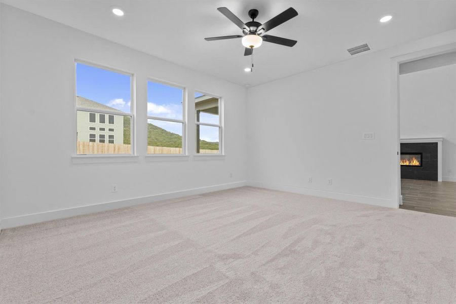 Carpeted empty room with ceiling fan