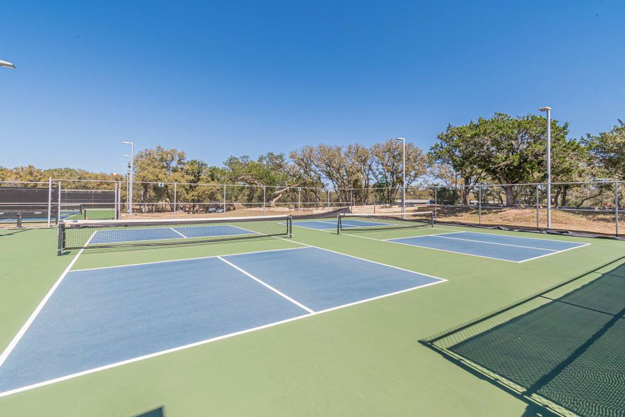 View of tennis court with community basketball court and fence