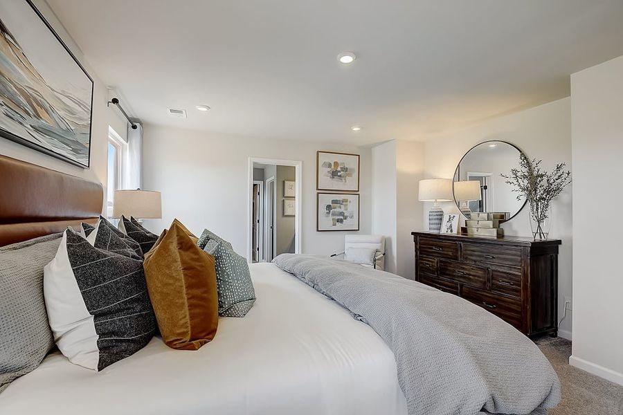 A bedroom with a bed and a mirror.