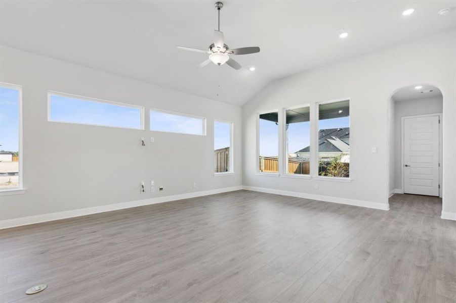 Unfurnished living room with ceiling fan, lofted ceiling, and light hardwood / wood-style flooring