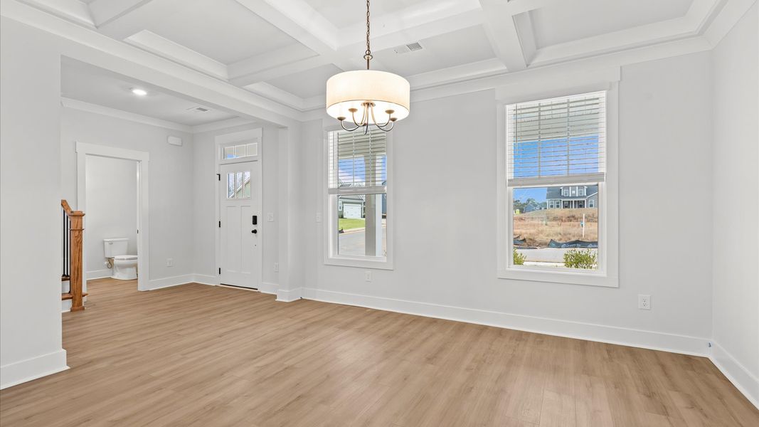 Desirable dining room with coffered ceiling and modern elegance in an established community Desirable dining room with coffered ceiling and modern elegance in an established community