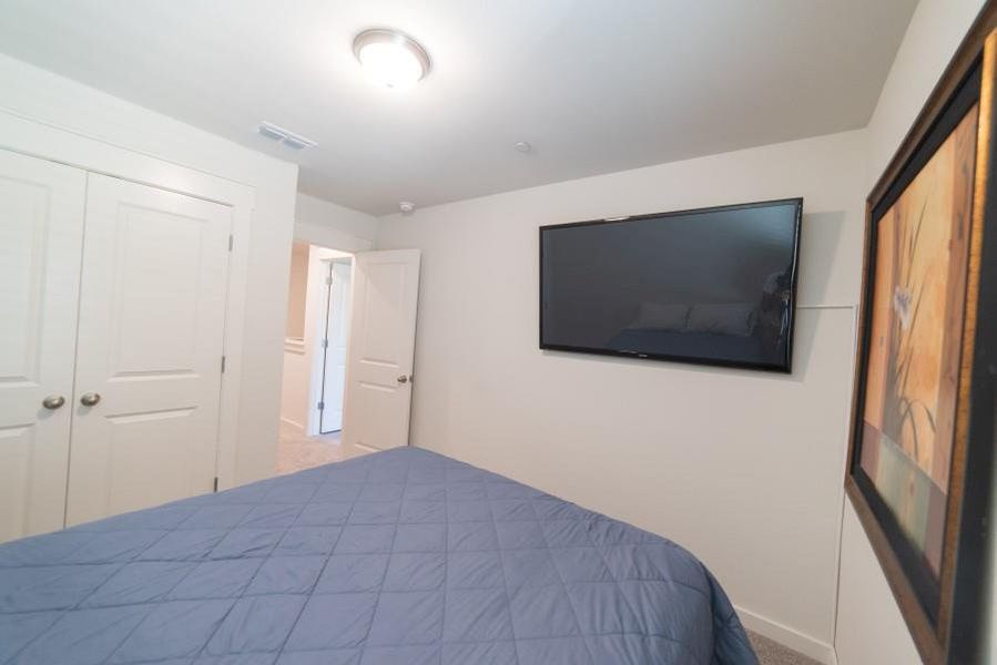 Carpeted bedroom with a closet