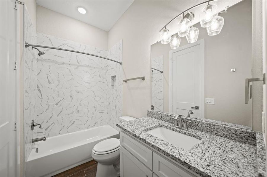 Secondary Bathroom with tile floors, a shower/tub combo with recessed lighting, granite countertops, and a large mirror.