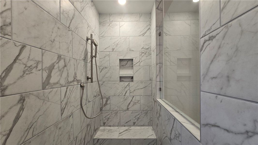 Elegantly veined marble-look tile wraps this moder