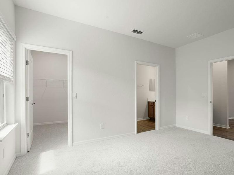 The bedroom 2 suite is located off a private hallway at the garage entry - Everly by Highland Homes