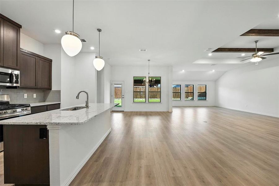 Kitchen featuring stainless steel appliances, open floor plan, recessed lighting, light wood finished floors, and tasteful backsplash