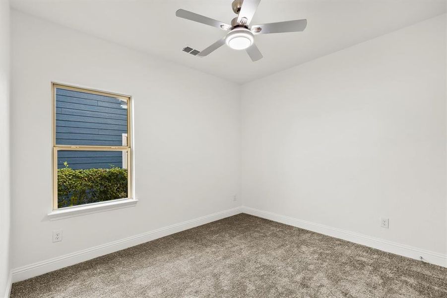 Carpeted empty room with ceiling fan