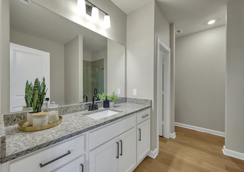 Primary bathroom featuring a white vanity with a cultured marble countertop and a large mirror.