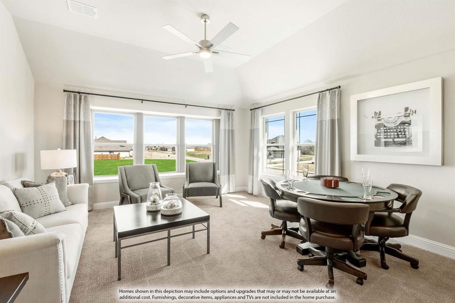 Living room with vaulted ceiling, ceiling fan, carpet flooring, seating area, and round game table near large windows.