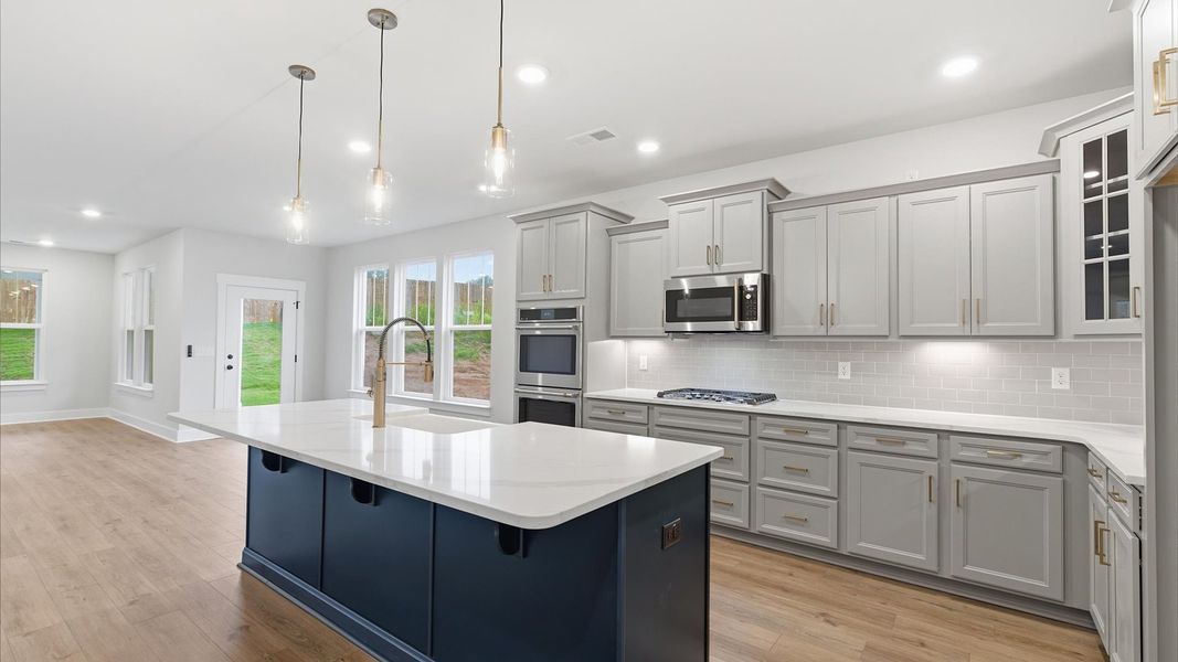Memorable meals begin in this vibrant kitchen with pendant lighting and a thoughtfully designed island at Woodglen Memorable meals begin in this vibrant kitchen with pendant lighting and a thoughtfully designed island at Woodglen