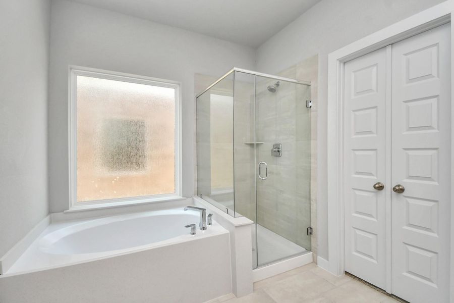 Indulge in a spa-like retreat within the confines of this primary bathroom. Delight in a spacious walk-in shower enveloped in stylish tile surround and unwind in a separate garden tub adorned with custom detailing. Indulge in a spa-like retreat within the confines of this primary bathroom. Delight in a spacious walk-in shower enveloped in stylish tile surround and unwind in a separate garden tub adorned with custom detailing.