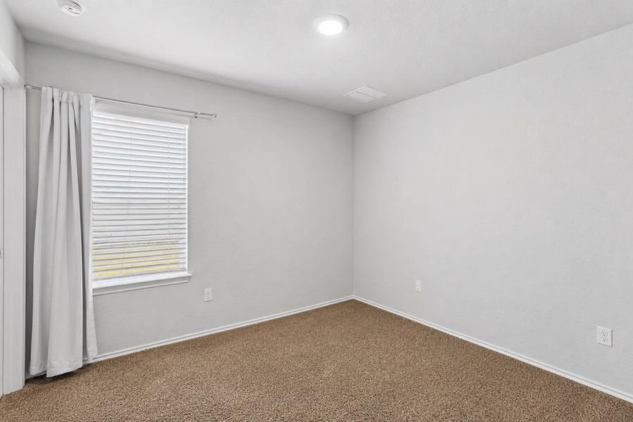 A well-lit bedroom with plush carpeting, offering a clean and inviting canvas for personalization. A well-lit bedroom with plush carpeting, offering a clean and inviting canvas for personalization.