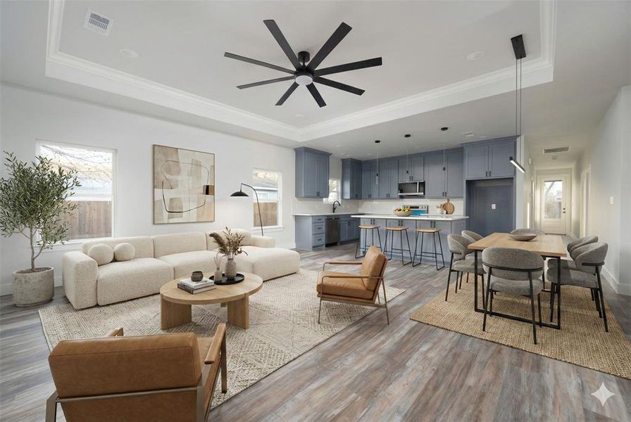 Virtually generated decoration. Living area featuring light wood-style flooring, plenty of natural light, ceiling fan, ornamental molding, and a raised ceiling